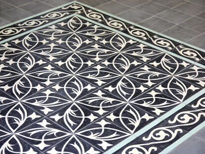 Verlegte Bodenfläche mit Zementfliesen in Schwarz und Weiß - Jugendstilfliesen als Zementfliesen