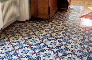 Raum mit antiken Möbeln und alten Fliesen mit Dekor auf dem Boden