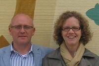 Dieter Dichantz und Silke Wiegand, die Gründer von Casa:1 Feine Fliesen stehen vor einer bemalten Wand